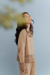 Camisa de lino blanca con detalles de encaje crochet en los puños y en el ruedo. Presenta un diseño romántico con cierre frontal de botones.