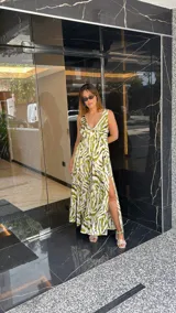 Vestido largo estampado con escote en V profundo y tirantes anchos. El diseño presenta un frunce o nudo en el centro del busto y tajos laterales en la falda.