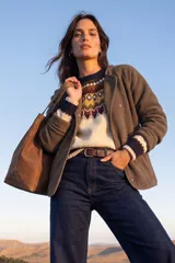 Campera de polar color gris, con cierre frontal de botones a presión, cuello redondo y mangas largas con puños acanalados.