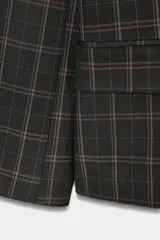 Blazer de corte recto con estampado de cuadros, cuello solapa y manga larga con hombreras. Presenta cierre frontal con botones ocultos bajo solapa y bolsillos delanteros con solapa.