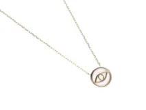 Collar de plata con baño de oro y dije circular de nácar con un ojo de la suerte.