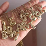 Collar dorado con dije de letra chunky.