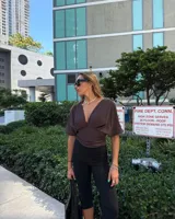 Top marrón con escote en V pronunciado, mangas cortas amplias y detalle fruncido en la cintura.
