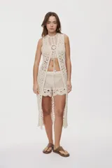 Short de crochet color beige, con calce relajado y tiro medio, diseño de tejido calado con detalles artesanales y terminaciones onduladas en el ruedo.