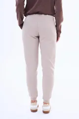 Pantalón de jogging de felpa, color beige, con cintura elástica ajustable mediante cordón y puños acanalados en los tobillos.