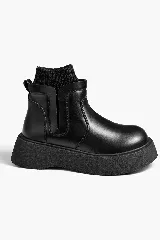 Bota corta de cuero sintético negro con suela de plataforma gruesa y detalle de media de punto acanalado integrada en la parte superior.