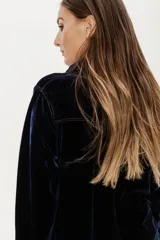 Camisa azul de terciopelo con corte estilo jean, bolsillo en la parte delantera y botones símil metal color oro viejo.
