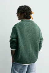 Jersey de hombre de corte relajado, tejido en hilado texturado color verde bosque, con cuello redondo y manga larga.