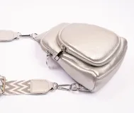 Bandolera plateada de cuero sintético con dos compartimentos con cierre.