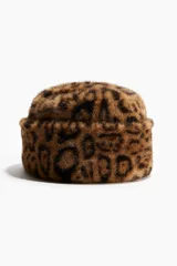 Gorro de estilo bucket con textura de pelo sintético y estampado de leopardo. Presenta un diseño con doblez ancho y forro interior.