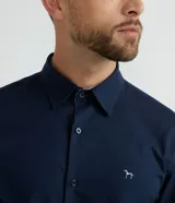 Camisa de vestir azul marino, corte slim fit, de tela Oxford, con cuello camisero y cierre con botones.