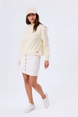 Buzo de piqué color beige, de manga larga, cuello redondo y diseño liso.