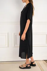 Túnica midi de color negro, con escote en V, mangas cortas y corte holgado. Confeccionada en una mezcla de viscosa y lino, ofrece una caída ligera y cómoda.