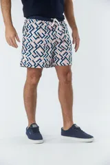 Short de baño azul marino con estampado de hojas de palmera color salmón.
