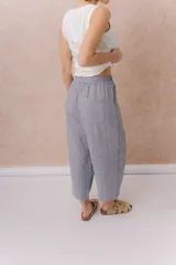 Pantalón de lino liviano color gris, con calce amplio, relajado, pierna ancha y caída fluida. Cuenta con cintura elástica y bolsillos laterales.