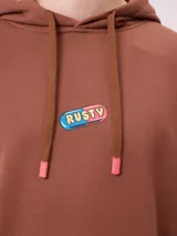 Canguro marrón con capucha y bolsillo frontal, con un diseño gráfico colorido en la espalda que representa una casa surrealista con el texto 'Supreal State of Mind'.