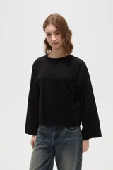 Remera de manga larga confeccionada en viscosa, con cuello redondo a la base y diseño holgado.