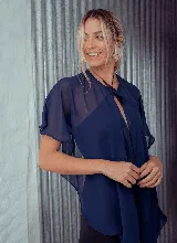 Capa azul marino de gasa, estilo torerita, con mangas cortas amplias y lazo de ajuste en el cuello.