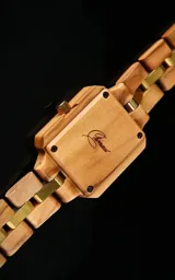 Reloj de pulsera con caja cuadrada de madera de olivo y esfera verde con marcadores minimalistas y agujas doradas. La malla es de madera de olivo con eslabones centrales metálicos en tono dorado.
