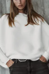 Sweater de punto blanco con textura acanalada horizontal, cuello barco, mangas largas amplias y corte holgado.