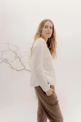 Remera de manga larga con escote a la base, color blanco, con un bordado central de dos líneas negras verticales en la parte delantera. La parte delantera es de lino y la espalda de algodón con spandex.