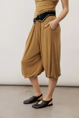 Pantalón holgado negro tipo bombacho, con cintura elástica y puños fruncidos en los tobillos.