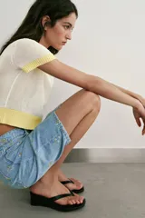 Top de punto color crudo con cuello redondo, manga corta y detalles de rib en color amarillo en el cuello, los puños y el ruedo.
