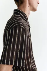 Camisa de manga corta en punto texturizado, de corte estándar, con diseño a rayas verticales en color marrón y blanco, cuello y cierre frontal de botones.