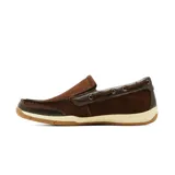 Mocasín de cuero negro estilo náutico, con costuras pespunteadas visibles, cordón decorativo lateral que pasa por ojalillos metálicos, suela de goma blanca y base caramelo con estriado antideslizante.