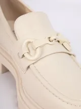 Mocasín negro de cuero sintético con aplique metálico plateado y suela de plataforma track.