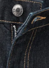 Jeans de mezclilla de corte holgado y tiro medio, en color azul oscuro, con diseño clásico de cinco bolsillos y costuras visibles en contraste.