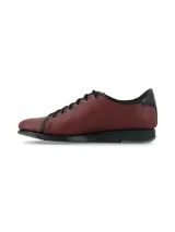 Zapatillas de cuero napa color bordó, con cordones y suela anatómica de goma negra. Presenta detalles en color negro en la cordonera, el borde superior y el talón.