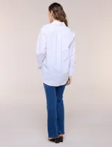 Camisa blanca de corte holgado, marca Magaschoni, con cuello camisero, mangas largas con puños anchos, bolsillo en el pecho y ruedo curvo.