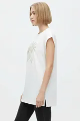 Remera negra de algodón, con cuello redondo, mangas cortas holgadas con vuelta y estampa floral grande en el pecho.