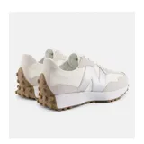 Championes urbanos New Balance modelo 327, con diseño inspirado en el running de los años 70. Presentan una combinación de paneles en tonos crema y beige, con el logo 'N' lateral en color plateado metalizado y suela de goma con relieve extendido hacia el talón.