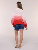 Cárdigan de punto abierto y calado con silueta holgada y hombros caídos, diseño degradado en tonos blanco, rosado y rojo. Presenta frente abierto sin botones y mangas largas abullonadas con terminación en puño acanalado.