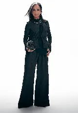 Blusa negra con estampado barroco en relieve, cuello alto, mangas largas y cierre frontal con lazo.