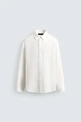 Camisa de corte regular confeccionada en tejido con mezcla de lyocell, con cuello solapa, manga larga con puños abotonados y cierre frontal de botones.