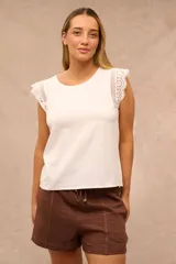 Blusa sin mangas color crudo, con cuello redondo y detalles de encaje inglés en los hombros.