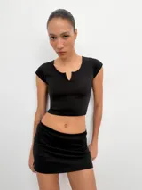 Falda corta gris melange de tiro medio con cintura elástica, confeccionada en hilatura con mezcla de algodón. Cuenta con forro interior tipo shorts del mismo tejido.