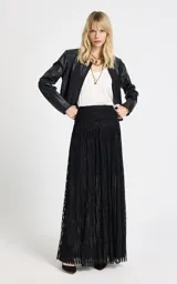 Pollera larga de tiro alto confeccionada en tejido de punto con acabado brillante de lurex. Presenta una cintura ancha estructurada, diseño con sutil transparencia y forro interior, con cierre de cremallera invisible en la espalda.