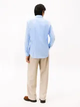 Camisa de manga larga para hombre, color celeste claro, con cuello con botones y corte slim. Presenta un pequeño logo bordado en el pecho.