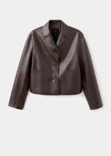 Chaqueta de piel sintética en color marrón, de diseño recto, manga larga y cuello con solapa. Cuenta con cierre frontal de botones, dos bolsillos laterales y forro interior.