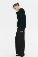 Pantalón amplio de punto bouclé color marrón oscuro, de tiro alto con elástico oculto en la cintura, bolsillos delanteros y cierre con botón.