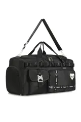 Bolso deportivo tipo duffel bag negro, con múltiples bolsillos frontales con tapa y correas ajustables. Incluye un dije de corazón blanco y cintas con la palabra "TRENDY" repetida.