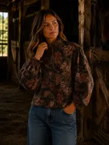 Camisa de lino con estampado floral en tonos tierra, cuello alto con volados, botones forrados y mangas largas abullonadas con puños elásticos.