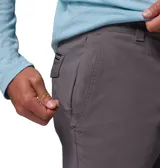 Pantalón chino Columbia modelo Roc Chino Pant, color gris, de corte recto con trabillas para cinturón, bolsillos inclinados y bolsillo lateral con cierre de cremallera.