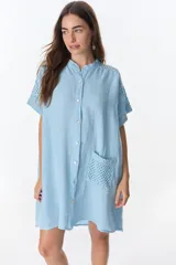 Vestido camisero marrón de lino con mangas cortas, cuello mao, cierre frontal con botones y bolsillo de crochet.