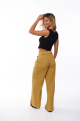 Pantalón de vestir color mostaza, de corte palazzo, con pinzas en la cintura y bolsillos laterales.