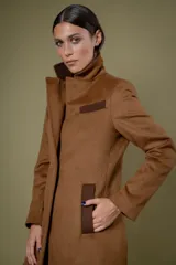 Tapado de corte sastre con diseño de espiga en tonos blanco y negro. Cuenta con solapas clásicas, cierre frontal de un botón y bolsillos laterales.